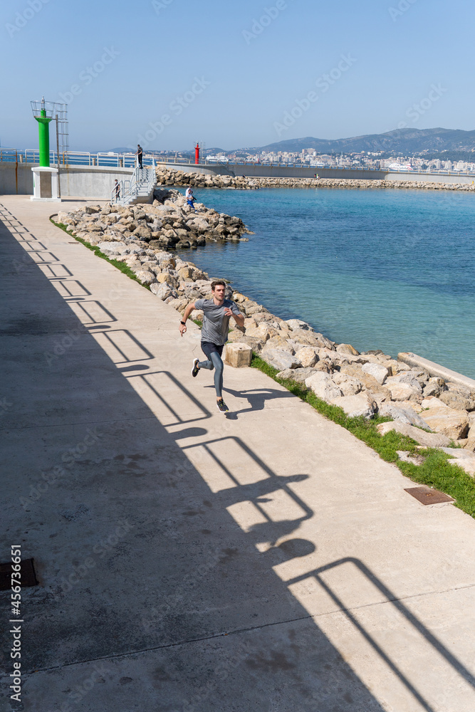 Young man running by port