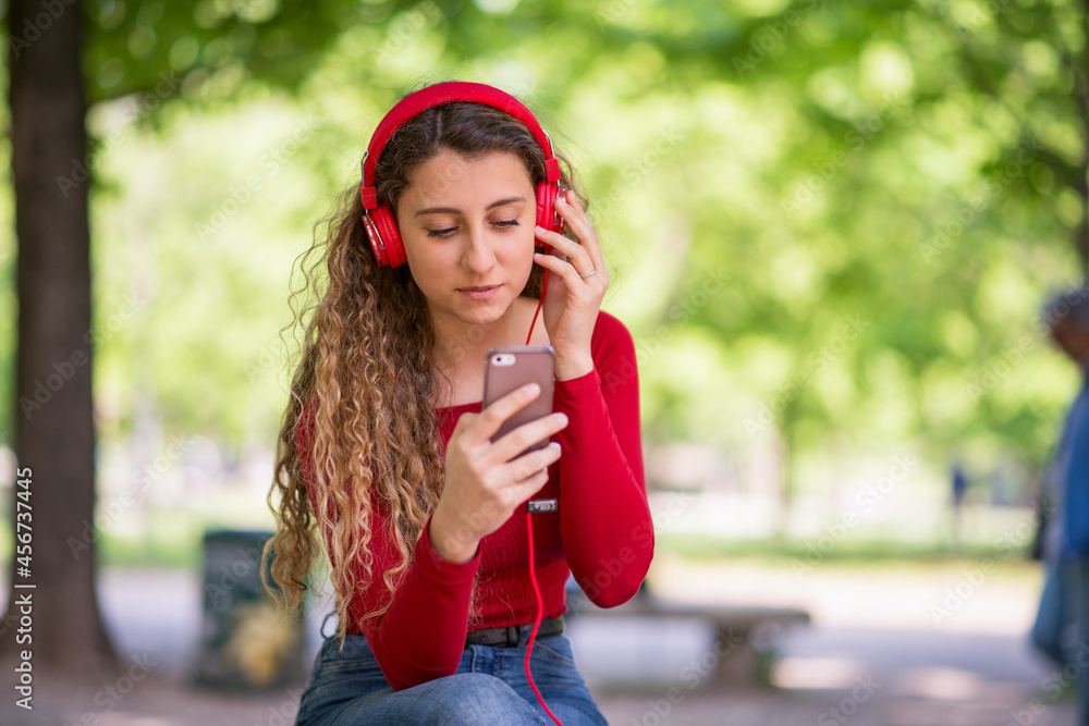 Fototapeta premium Teenager listening music in a park