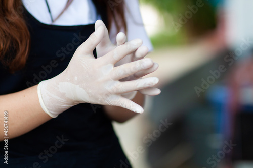 Close up woman wearing rubber gloves to prevent germs.