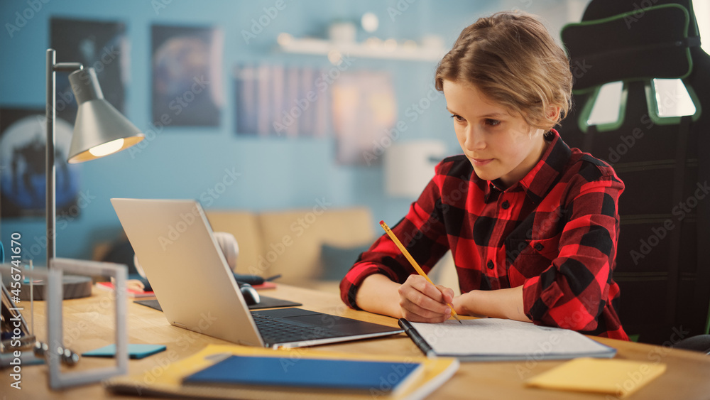 Smart Young Boy in Checkered Shirt Attending Online Class on Laptop Computer in Cozy Room at Home. Happy Teenager Browsing Educational Research Online, Writing in Notebook, Studying School Homework. Smart Young Boy in Checkered Shirt Attending Online Class on Laptop Computer in Cozy Room at Home. Happy Teenager Browsing Educational Research Online, Writing in Notebook, Studying School Homework.