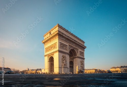 Triumphal Arch with sculptures on pavement at dawn photo