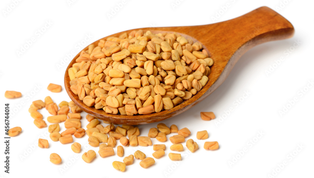 fenugreek seeds in the wooden spoon, isolated on the white background fenugreek seeds in the wooden spoon, isolated on the white background