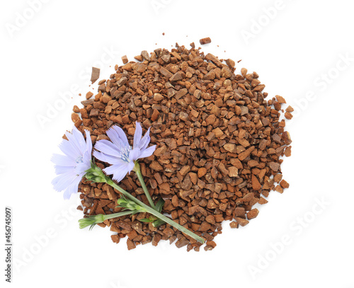 Pile of chicory granules and flowers on white background, top view