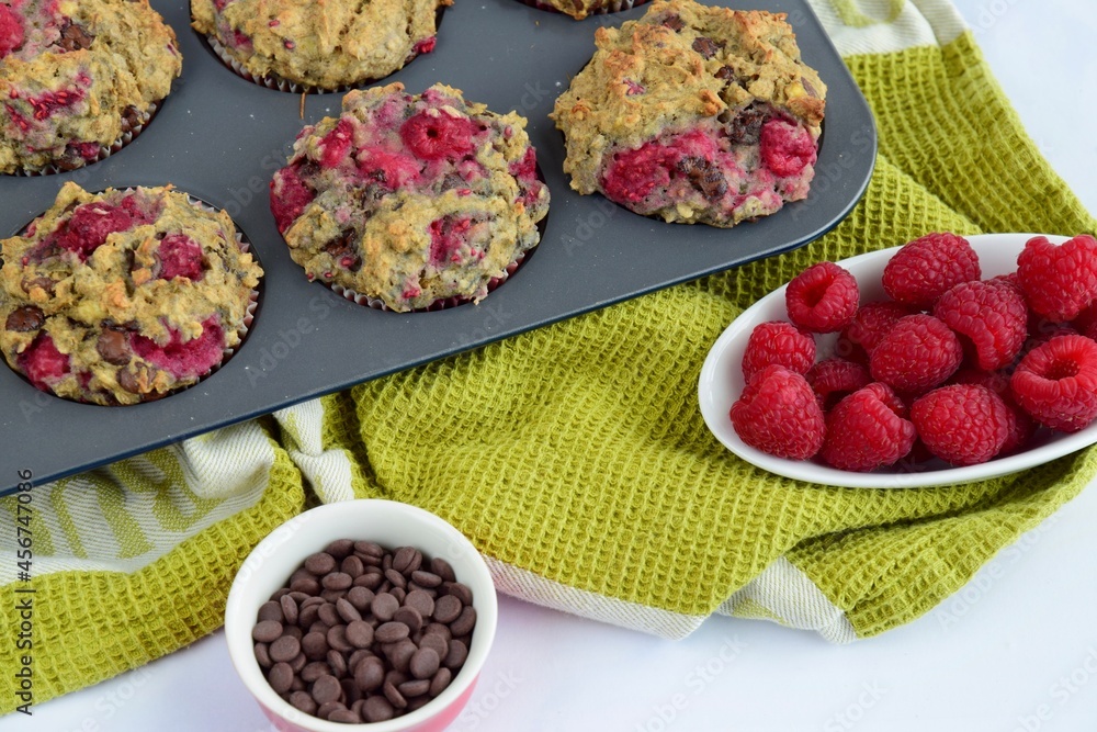 Freshly baked raspberry banana chocolate chip muffins on muffin pan Freshly baked raspberry banana chocolate chip muffins on muffin pan
