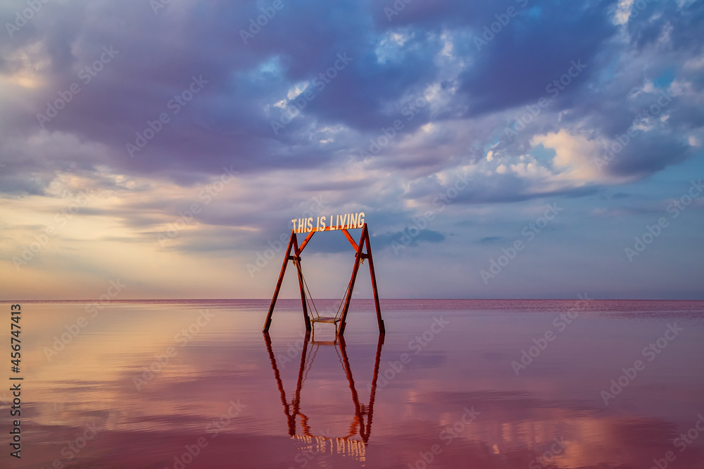 Fototapeta premium Swing in the pink salt lake Sivash. A place in Ukraine for treatment and walks.