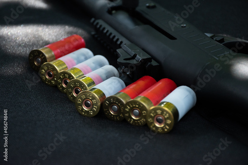 Shotgun, shotgun cartridges on a black leather background