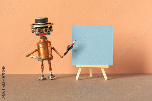 Carta da parati Robot guide poses with a pencil next to a wooden easel and a blank sheet of blue paper