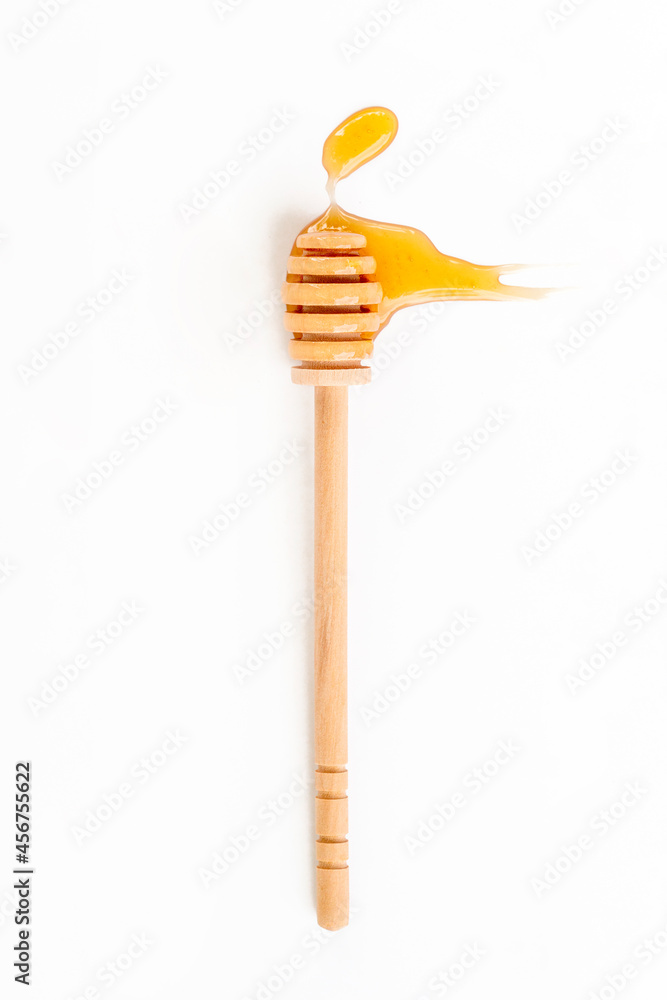 Drops of honey and honey wooden spoon on white background, top view Drops of honey and honey wooden spoon on white background, top view