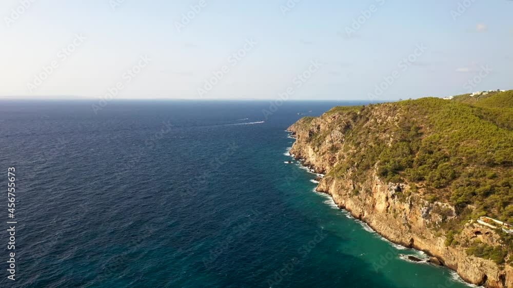 The beautiful beach front of the Island of Ibiza in Spain, taken with a drone in the summer time showing the cliffs and ocean on the Island The beautiful beach front of the Island of Ibiza in Spain, taken with a drone in the summer time showing the cliffs and ocean on the Island