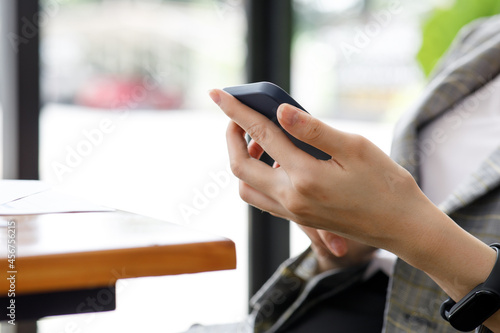 image of a businesswoman hand using her smartphone at an office meeting,blur background.