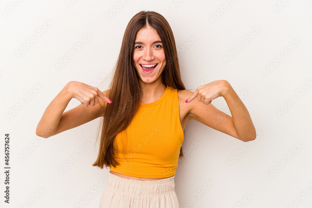 Young caucasian woman isolated on white background surprised pointing with finger, smiling broadly. Young caucasian woman isolated on white background surprised pointing with finger, smiling broadly.