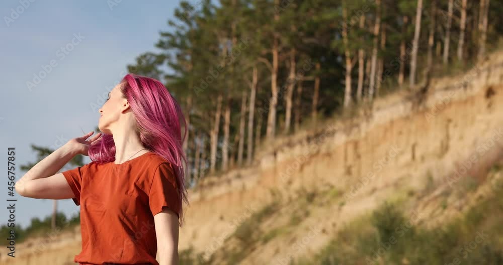 woman with pink hair enjoying the sun and wind on the beach woman with pink hair enjoying the sun and wind on the beach