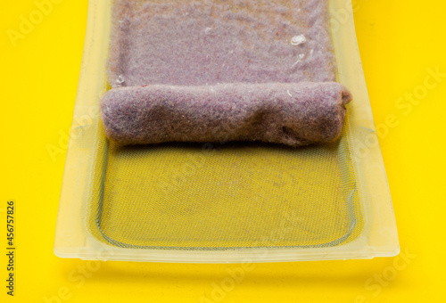 Laundry lint trap or screen on yellow photo