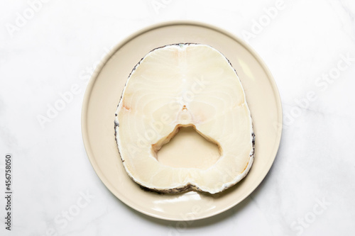 Snow fish on plate for delicious good meal. Snow fish are found in the deep ocean  thick flake and melt-in-your-mouth texture. Isolated on white marble table background.
