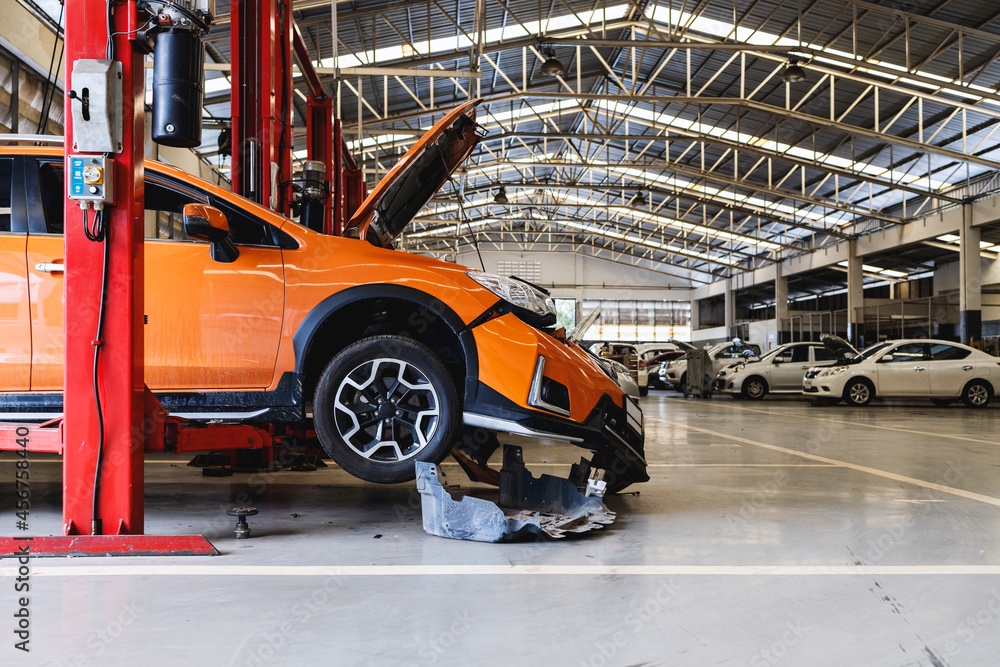 Fototapeta premium car in automobile repair service center with soft-focus and over light in the background