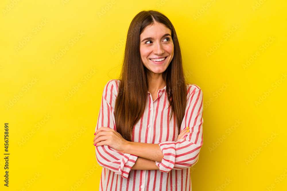 Obraz premium Young caucasian woman isolated on yellow background smiling confident with crossed arms.