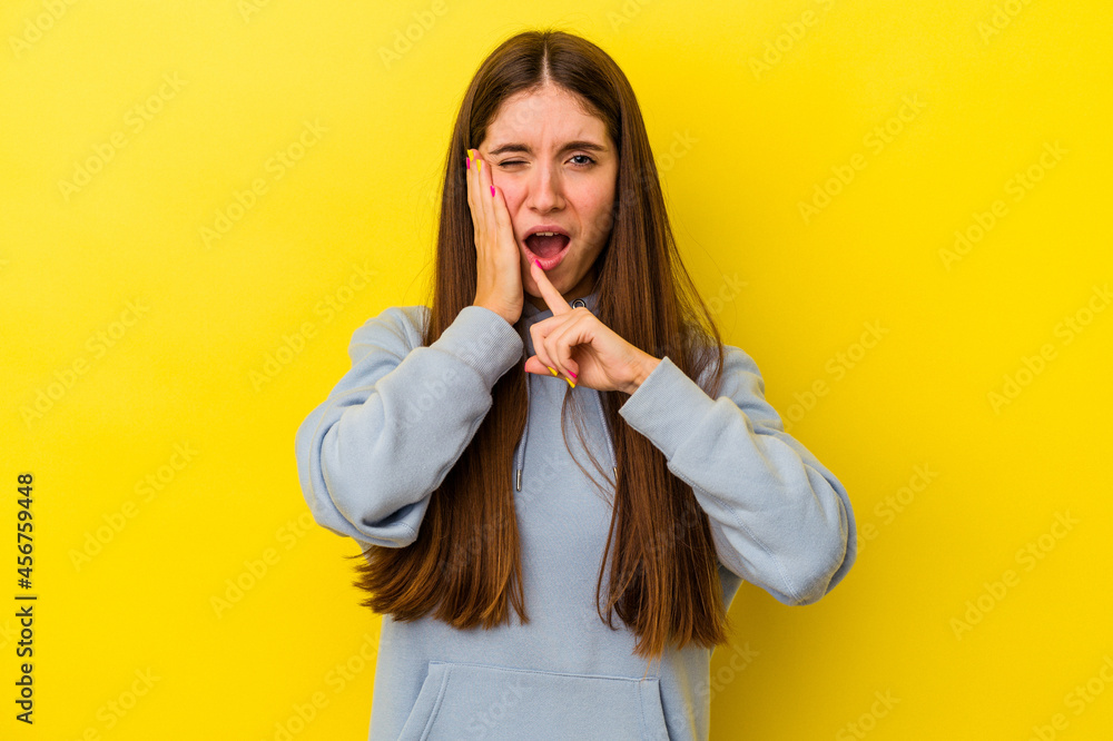 Young caucasian woman isolated on yellow background having a strong teeth pain, molar ache. Young caucasian woman isolated on yellow background having a strong teeth pain, molar ache.