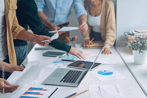 Close-up of modern people in smart casual analyzing data while having meeting in office