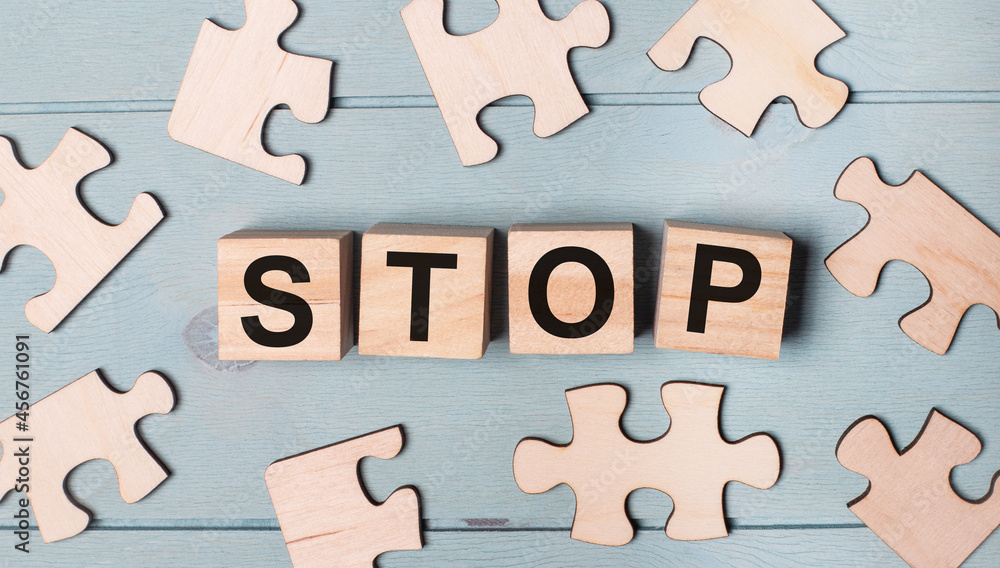 Blank puzzles and wooden cubes with the text STOP lie on a blue background. Blank puzzles and wooden cubes with the text STOP lie on a blue background.