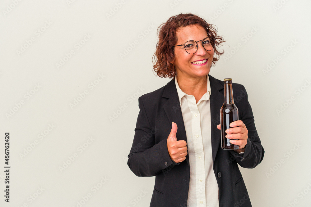 Middle age latin business woman holding a beer isolated on white background smiling and raising thumb up Middle age latin business woman holding a beer isolated on white background smiling and raising thumb up