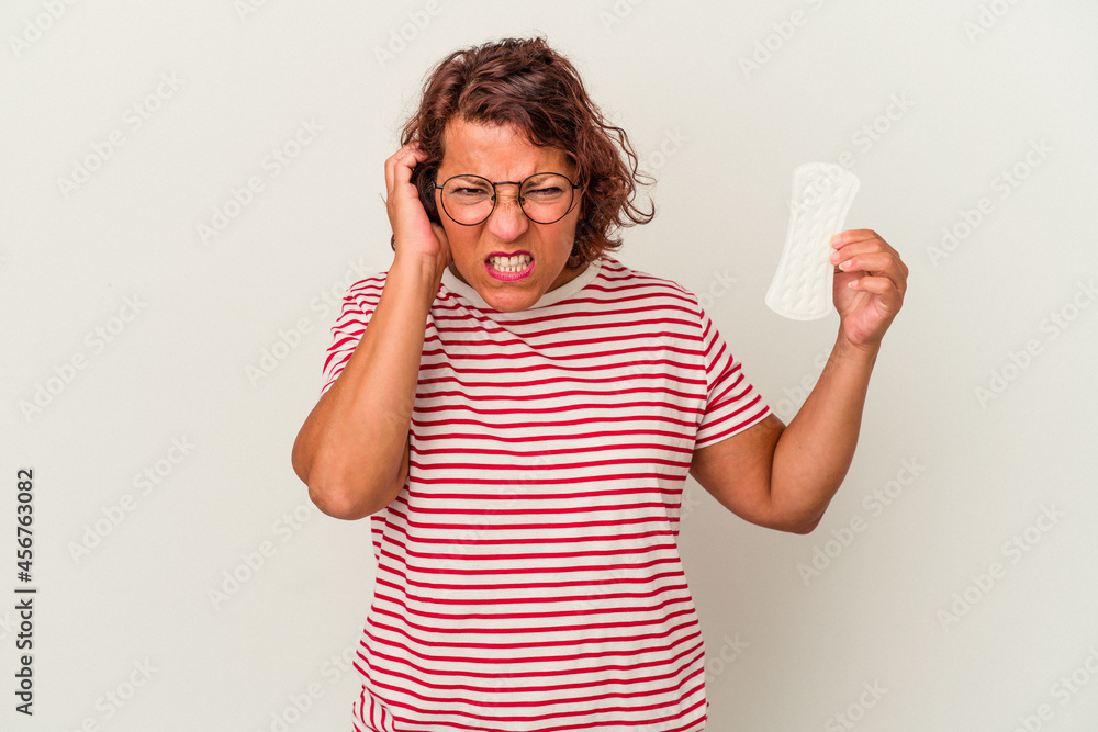 Middle age woman holding a compress isolated on white background covering ears with hands. Middle age woman holding a compress isolated on white background covering ears with hands.