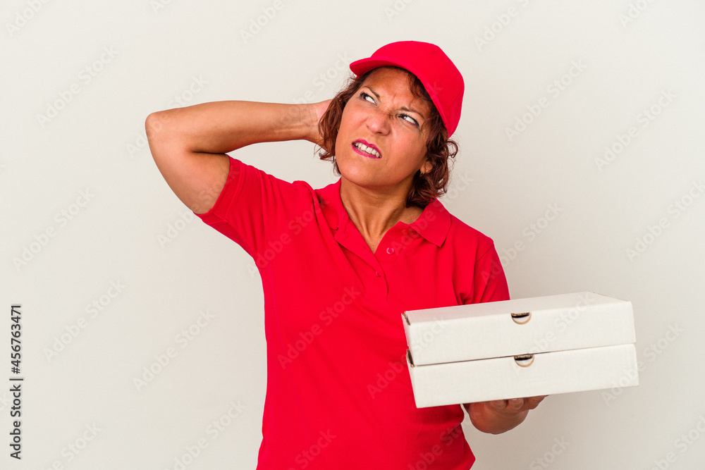 Middle age delivery woman taking pizzas isolated on white background touching back of head, thinking and making a choice. Middle age delivery woman taking pizzas isolated on white background touching back of head, thinking and making a choice.