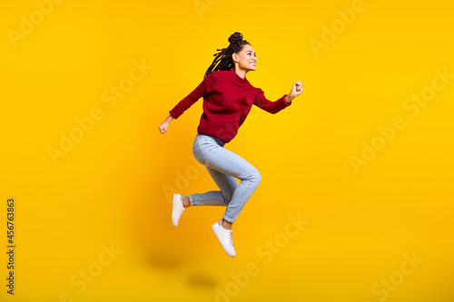 Full length high of charming pretty dark skin woman dressed red sweater jumping high running isolated yellow color background