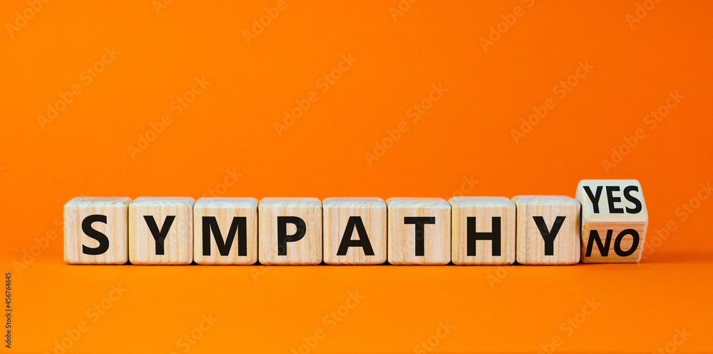 Sympathy yes or no symbol. Turned a wooden cube and changed words 'sympathy no' to 'sympathy yes'. Beautiful orange background. Business and sympathy yes or no concept, copy space. Sympathy yes or no symbol. Turned a wooden cube and changed words 'sympathy no' to 'sympathy yes'. Beautiful orange background. Business and sympathy yes or no concept, copy space.