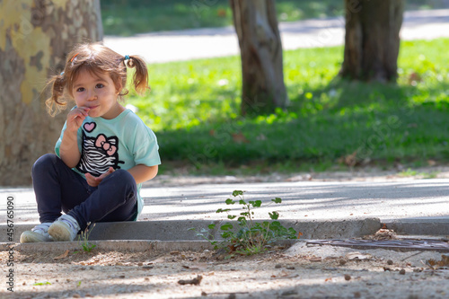 Wallpaper Mural Little girl with pigtails eating lollipop Torontodigital.ca