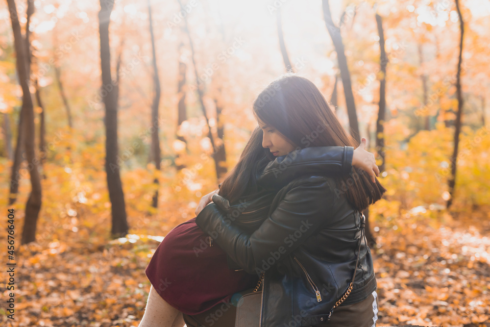 Mother and daughter spend time together in autumn yellow park. Season and single parent concept. Mother and daughter spend time together in autumn yellow park. Season and single parent concept.