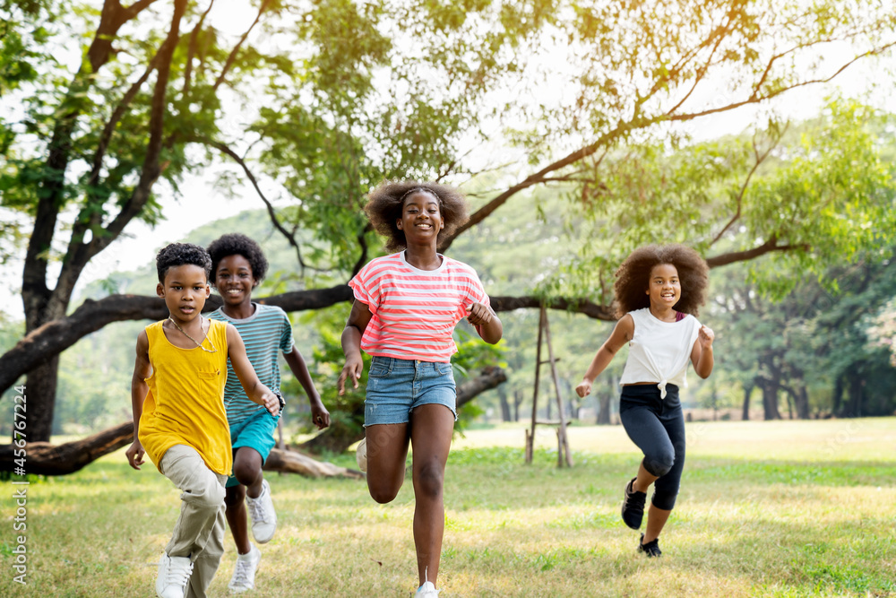 Group of cheerful kids running in the park in summer. Group of cheerful kids running in the park in summer.