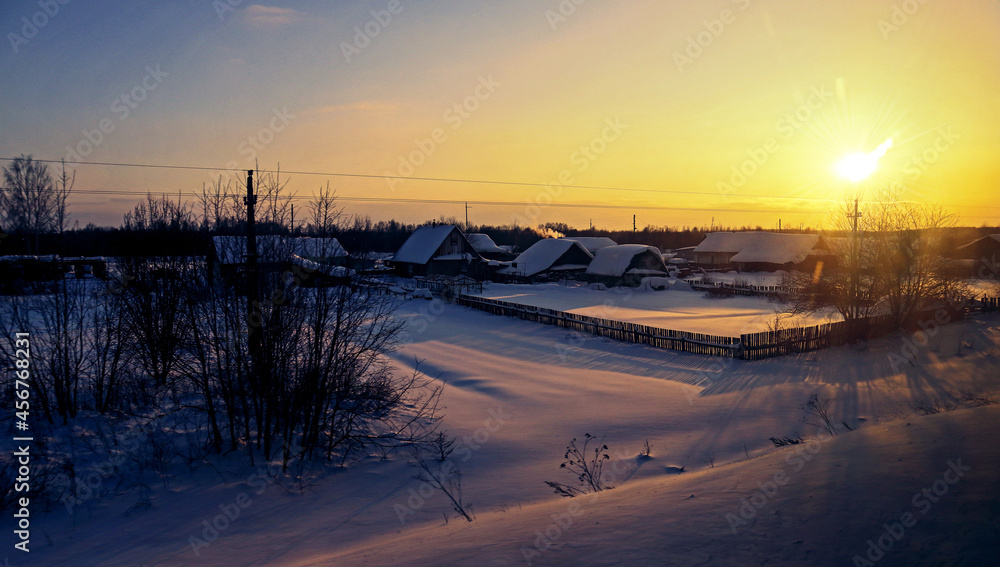 Sunset in winter forest. Sunbeams through snow-covered trees. Beautiful natural landscape on a frosty evening. Sunset in winter forest. Sunbeams through snow-covered trees. Beautiful natural landscape on a frosty evening.