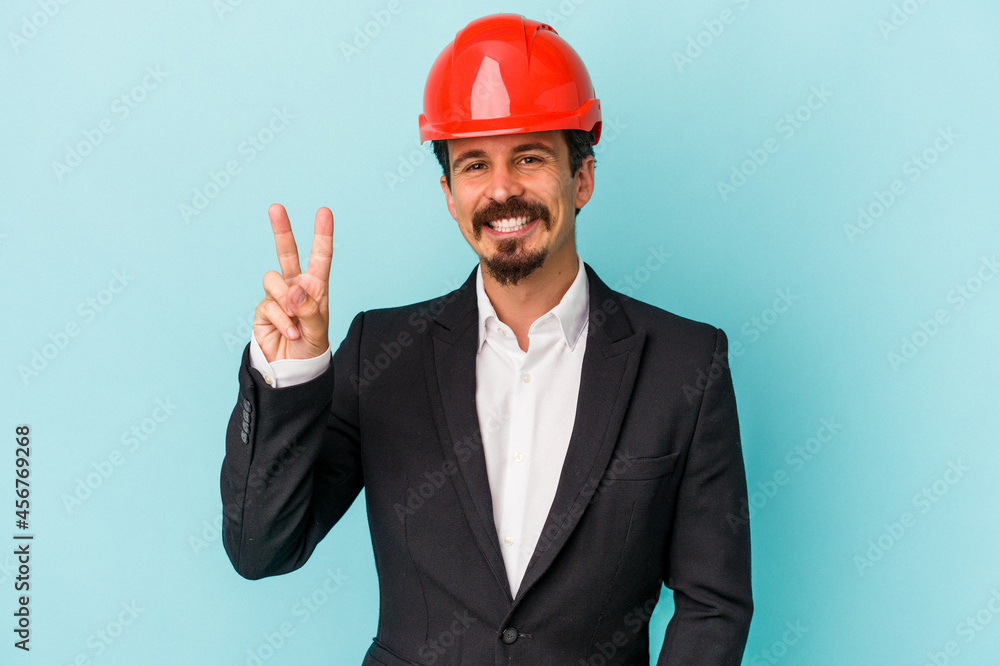 Young architect caucasian man isolated on blue background showing number two with fingers. Young architect caucasian man isolated on blue background showing number two with fingers.