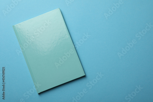 New turquoise planner on light blue background, top view. Space for text