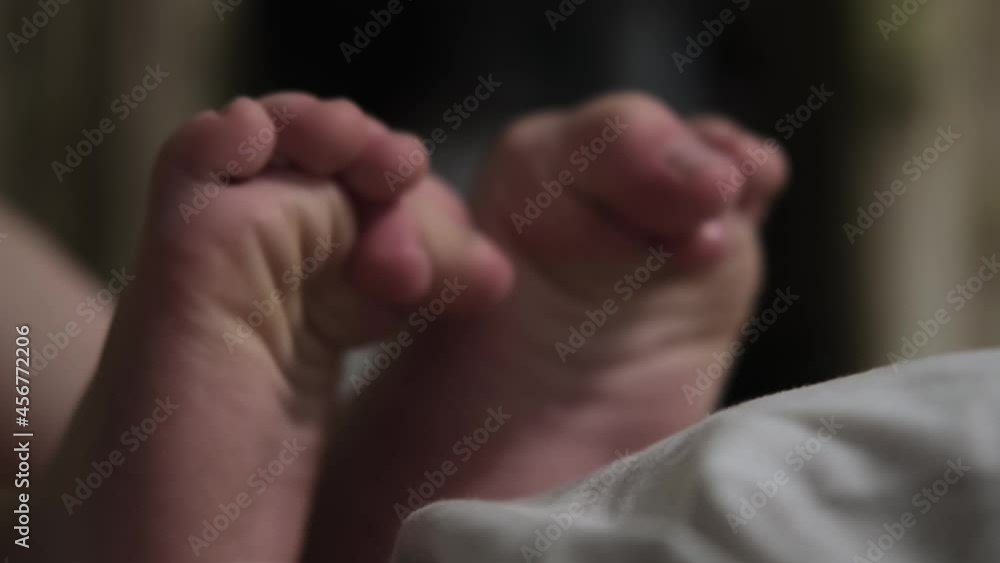 The child's feet move their toes in the bed. The child's feet move their toes in the bed.