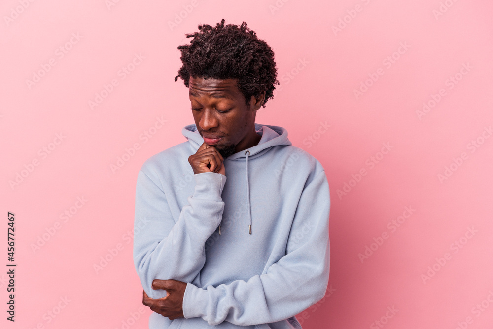 Young african american man isolated on pink background looking sideways with doubtful and skeptical expression. Young african american man isolated on pink background looking sideways with doubtful and skeptical expression.