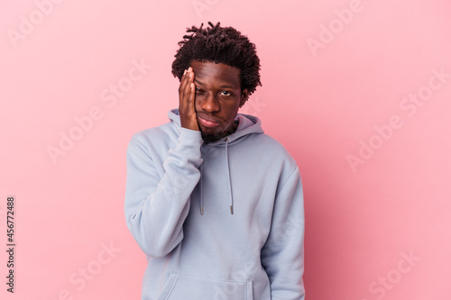 Young african american man isolated on pink background who feels sad and pensive, looking at copy space.