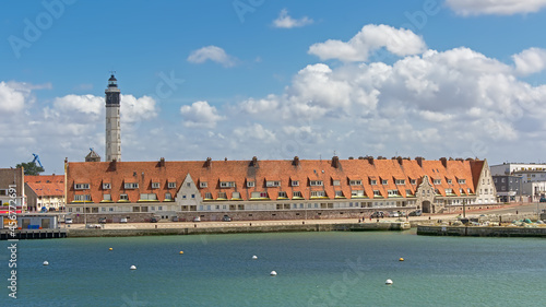 Tablou pe pânză Studio de la Matelot and lighthouse of Calais, France view from tacross the dock