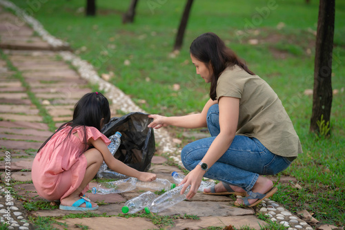 Asian mother and daughter help garbage collection charity environment. © reewungjunerr
