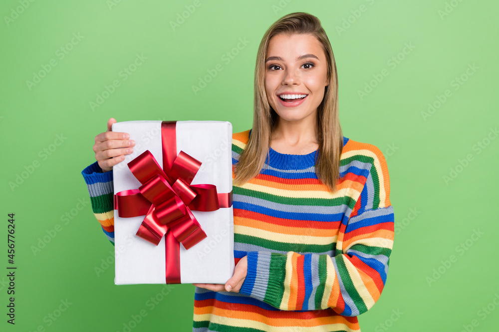 Photo portrait girl keeping present box smiling at birthday party laughing overjoyed isolated pastel green color background Photo portrait girl keeping present box smiling at birthday party laughing overjoyed isolated pastel green color background