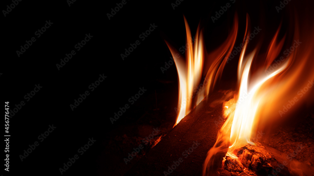 A bright fire flame on a black background. Dark abstract background