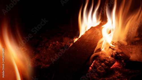 A bright fire flame on a black background. Dark abstract background