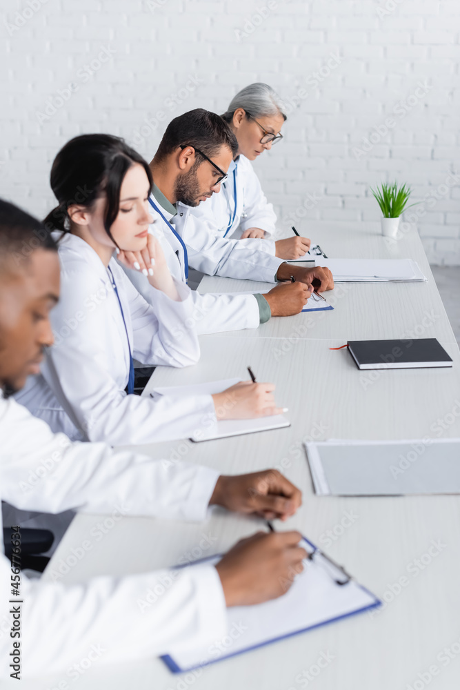 Fototapeta premium multiethnic doctors working with documents in hospital conference room