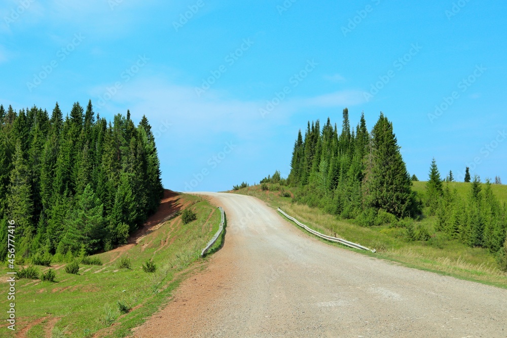 Fototapeta premium Dirt road going up the hill