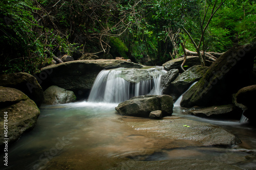 Waterfall in the midst of natural forest. The stream flowing through the rock channel.