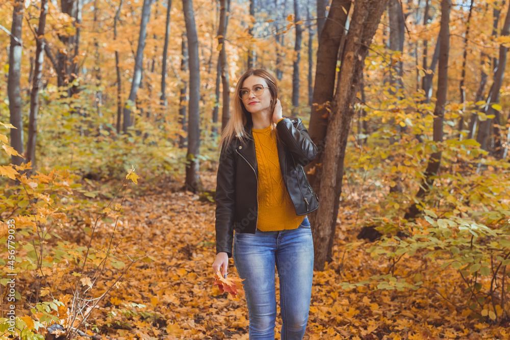 Girl holds fallen leaves and walks in autumn park. Seasonal concept. Girl holds fallen leaves and walks in autumn park. Seasonal concept.