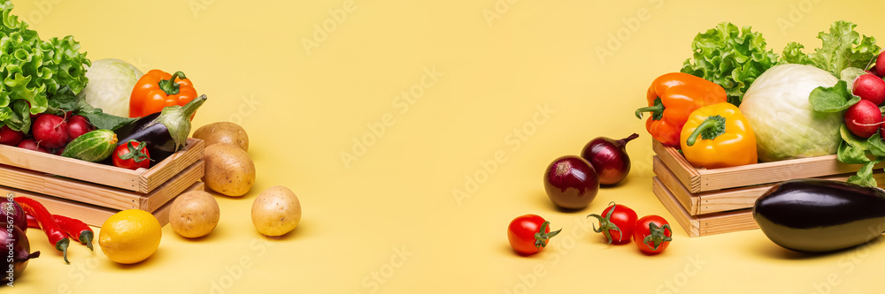 A set of fresh vegetables on a yellow background in wooden boxes. Potatoes,tomatoes, radishes,onions,cucumbers, eggplant, cabbage, pepper, lemon. Copy space. A set of fresh vegetables on a yellow background in wooden boxes. Potatoes,tomatoes, radishes,onions,cucumbers, eggplant, cabbage, pepper, lemon. Copy space.