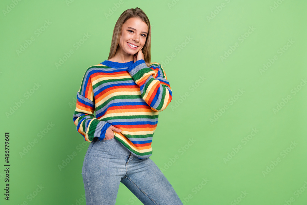 Photo portrait smiling girl wearing striped pullover stylish jeans smiling isolated pastel green color background Photo portrait smiling girl wearing striped pullover stylish jeans smiling isolated pastel green color background