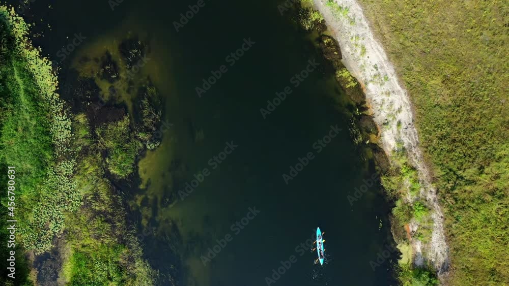 Top aerial view of a group of tourists sailing on a summer river on kayaks. Top aerial view of a group of tourists sailing on a summer river on kayaks.