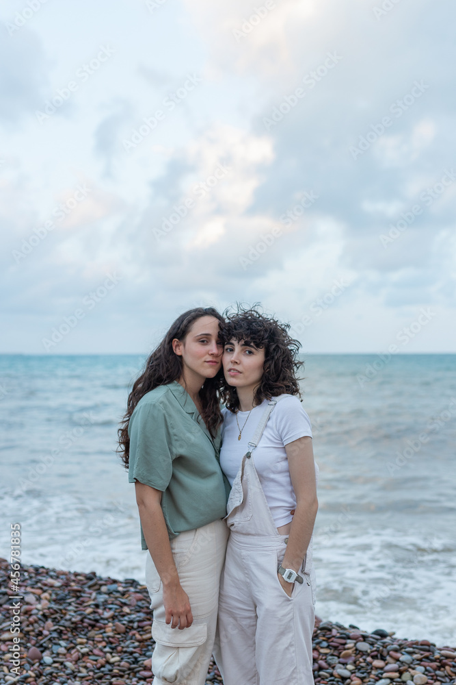 Homosexual couple of women embracing on sea shore Homosexual couple of women embracing on sea shore